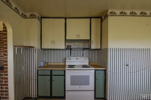 8970 Hurd Ln With 7, Acres, Payette, ID 83661 - kitchen featuring white range with electric cooktop, range hood, arched walkways, light countertops, and green cabinetry