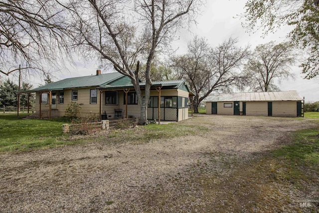 8970 Hurd Ln With 7, Acres, Payette, ID 83661 - rear view of house featuring metal roof, a chimney, an outbuilding, a sunroom, and a lawn