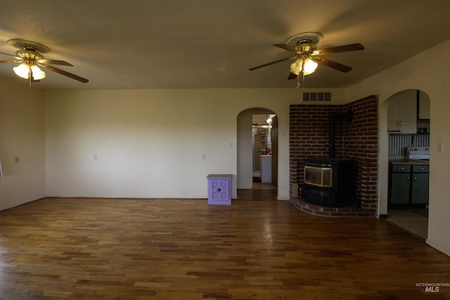 8970 Hurd Ln With 7, Acres, Payette, ID 83661 - unfurnished living room with a ceiling fan, wood finished floors, arched walkways, and a wood stove