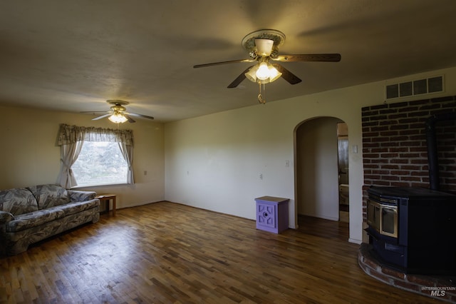 8970 Hurd Ln With 7, Acres, Payette, ID 83661 - unfurnished living room featuring ceiling fan, arched walkways, wood finished floors, and a wood stove