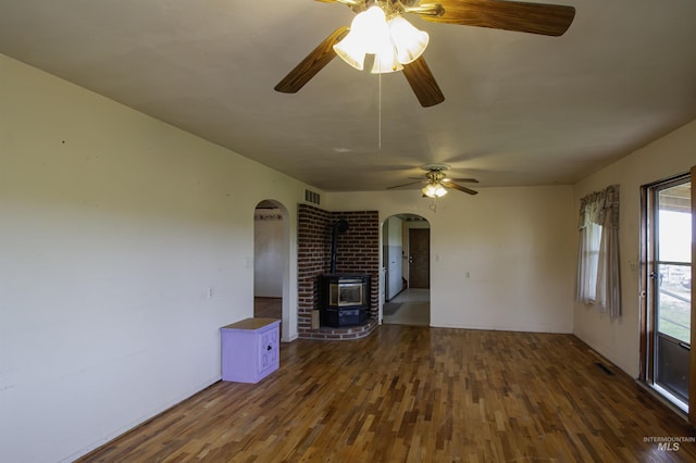 8970 Hurd Ln With 7, Acres, Payette, ID 83661 - unfurnished living room with a wood stove, arched walkways, a ceiling fan, and wood finished floors