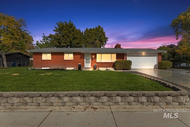 ranch-style house featuring a yard and a garage