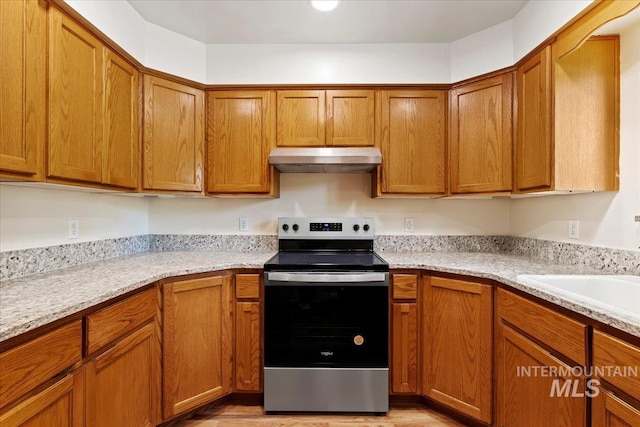 kitchen with sink, light stone countertops, and stainless steel electric range