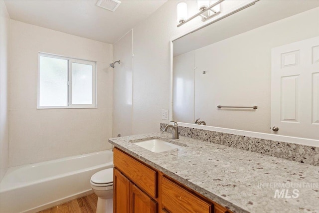 full bathroom with vanity, toilet, hardwood / wood-style flooring, and  shower combination