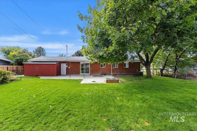 back of property with a yard and a patio area