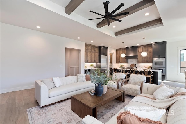 living area featuring recessed lighting, light wood-style flooring, beamed ceiling, ceiling fan, and baseboards
