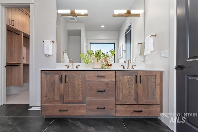 bathroom with double vanity, visible vents, tile patterned flooring, and a sink