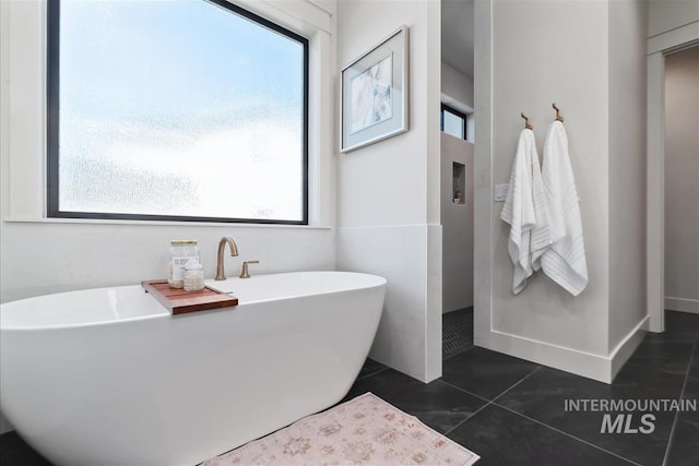 bathroom featuring tile patterned flooring and a soaking tub