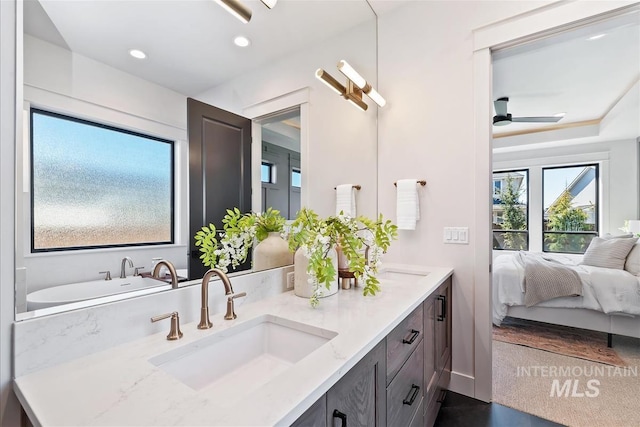 bathroom with recessed lighting, double vanity, a sink, and ceiling fan