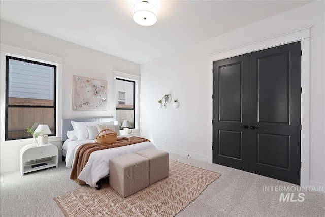 bedroom with baseboards, carpet flooring, and multiple windows