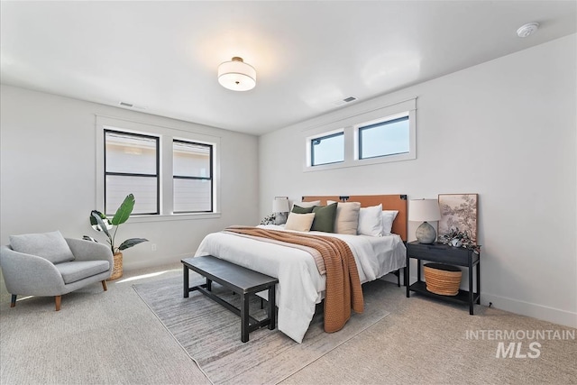 bedroom with light colored carpet, visible vents, and baseboards