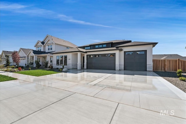 view of front of property with stucco siding, fence, a garage, driveway, and stone siding
