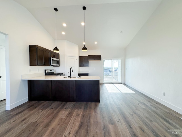 TBD Idaho, Caldwell, ID 83605 - kitchen with high vaulted ceiling, stainless steel microwave, a peninsula, dark brown cabinetry, and light countertops
