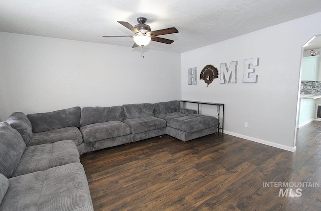 living room with dark wood-type flooring and ceiling fan