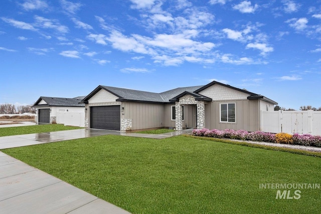 view of front of house with board and batten siding, a front yard, stone siding, and driveway