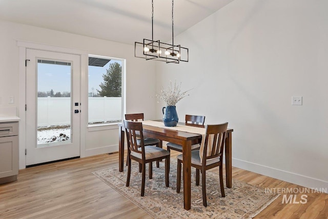 dining area featuring light wood-style floors and baseboards