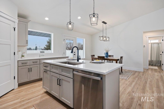 kitchen featuring dishwasher, hanging light fixtures, gray cabinets, light countertops, and a sink