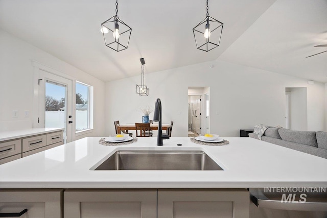 kitchen with open floor plan, light countertops, a sink, and lofted ceiling