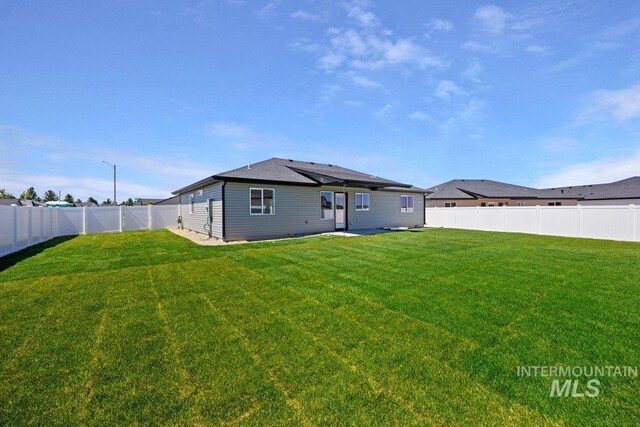 back of house featuring a fenced backyard and a yard