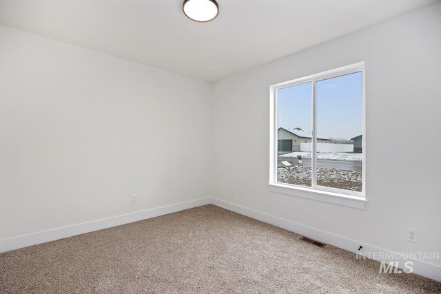 carpeted empty room with visible vents and baseboards