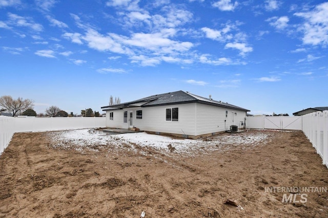 rear view of property with central air condition unit, a fenced backyard, and a gate