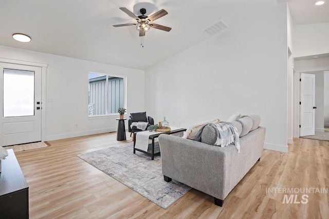 living room with lofted ceiling, baseboards, visible vents, and light wood finished floors