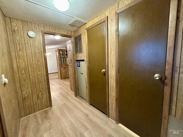 2934 SW Smith Rd, Mountain Home, ID 83647 - hall featuring wood walls, a textured ceiling, and light hardwood / wood-style flooring