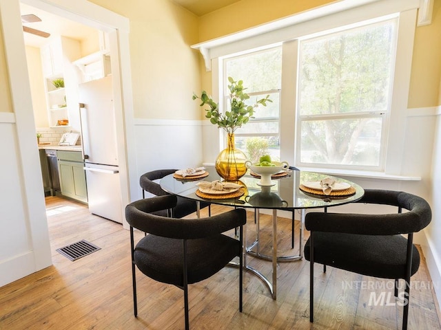 dining space featuring visible vents, breakfast area, and light wood-type flooring