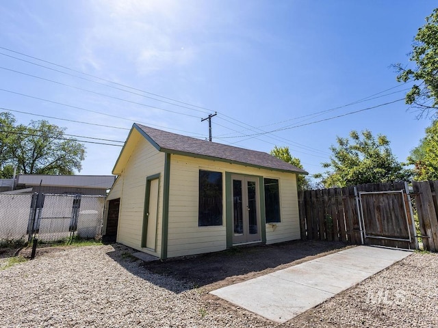 view of outdoor structure with an outdoor structure, a gate, fence, and french doors