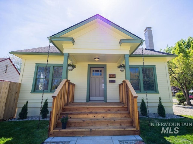 view of front of house featuring fence and a chimney