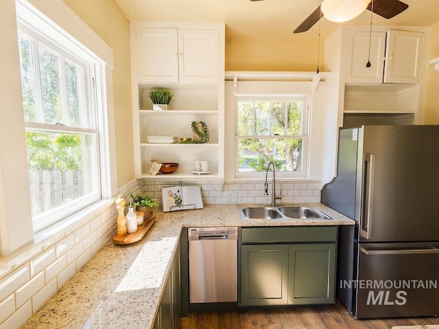 kitchen with a ceiling fan, tasteful backsplash, light stone counters, a sink, and stainless steel appliances