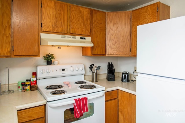 134 Maple Ave, Hansen, ID 83334 - kitchen with white appliances, under cabinet range hood, light countertops, and brown cabinetry