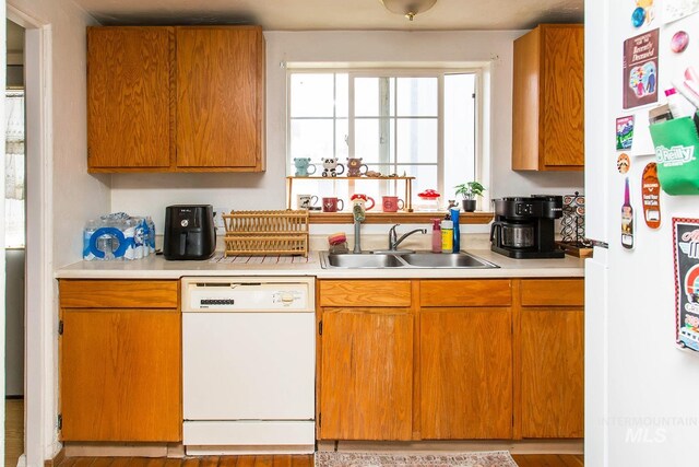 134 Maple Ave, Hansen, ID 83334 - kitchen with white appliances, light countertops, a sink, and brown cabinetry