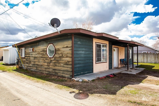 134 Maple Ave, Hansen, ID 83334 - view of side of home featuring fence, a patio, and a wall mounted air conditioner