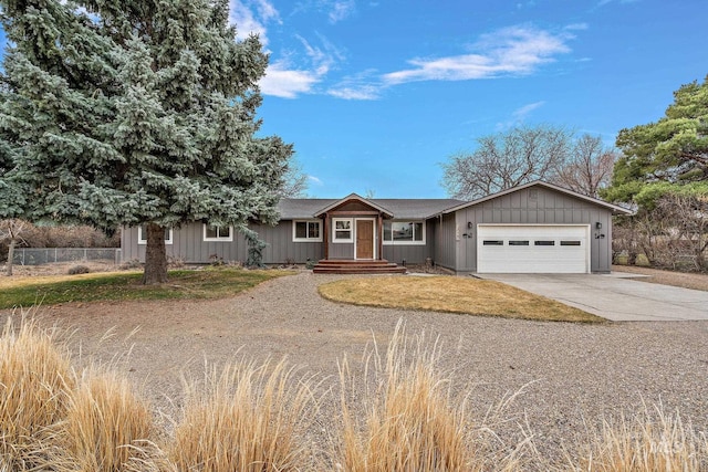 view of front of home with a garage, driveway, and fence