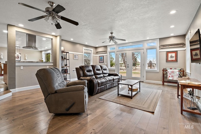 living room featuring french doors, wood-type flooring, and a textured ceiling