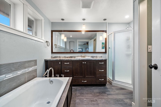 full bath with vanity, wood finished floors, visible vents, a shower stall, and a bath