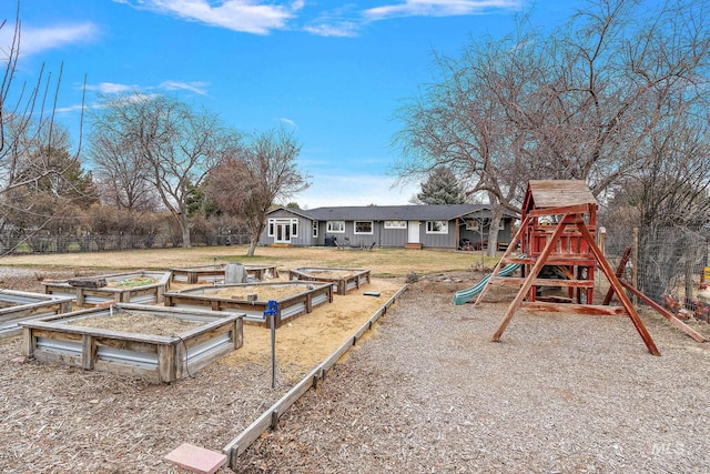 view of yard with a vegetable garden, fence, and a playground