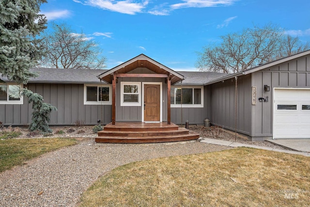 ranch-style home with an attached garage, a shingled roof, and board and batten siding