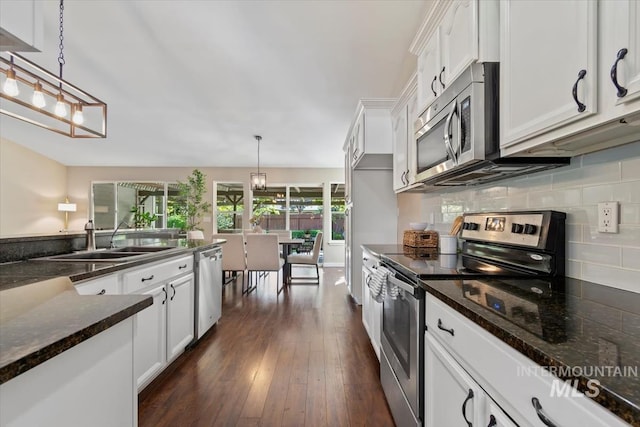6472 S Liveoak Pl, Boise, ID 83716 - kitchen with appliances with stainless steel finishes, a sink, white cabinets, tasteful backsplash, and dark wood-style flooring