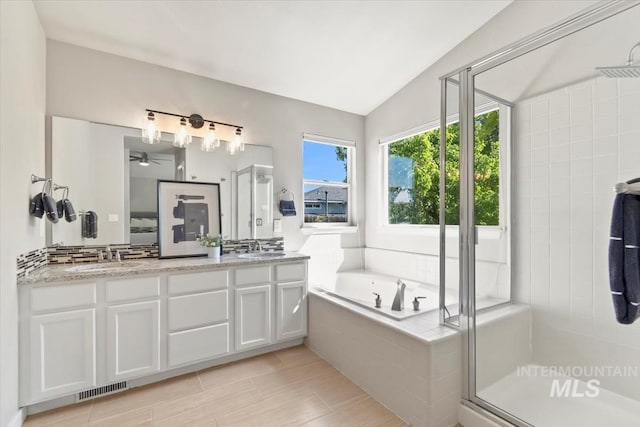 6472 S Liveoak Pl, Boise, ID 83716 - bathroom with double vanity, a bath, a shower stall, ceiling fan, and vaulted ceiling