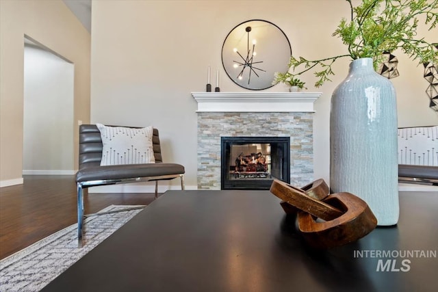 6472 S Liveoak Pl, Boise, ID 83716 - living area with wood finished floors, baseboards, a chandelier, and a stone fireplace