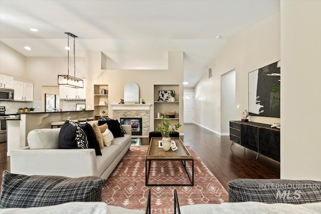 6472 S Liveoak Pl, Boise, ID 83716 - living room with dark wood finished floors, baseboards, vaulted ceiling, a stone fireplace, and recessed lighting