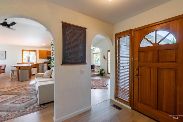 12281 W Norway St, Boise, ID 83713 - foyer entrance with arched walkways, ceiling fan, light wood finished floors, and baseboards