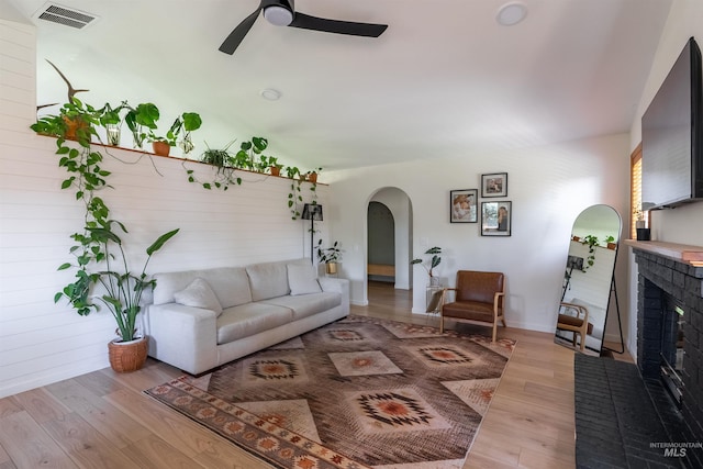 12281 W Norway St, Boise, ID 83713 - living area featuring arched walkways, ceiling fan, light wood finished floors, a fireplace, and baseboards