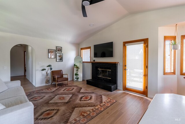 12281 W Norway St, Boise, ID 83713 - living room featuring lofted ceiling, ceiling fan, arched walkways, a brick fireplace, and wood finished floors