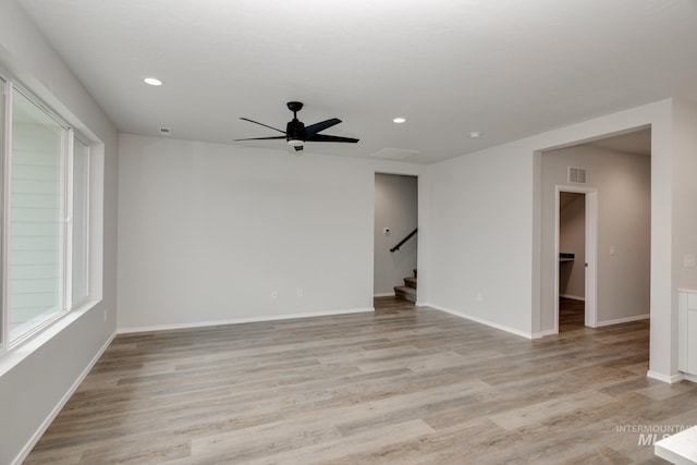 empty room featuring stairway, light wood-type flooring, visible vents, and recessed lighting