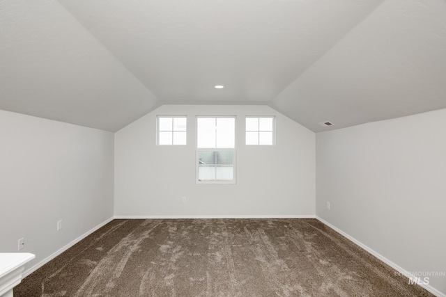 bonus room featuring lofted ceiling, carpet, visible vents, and baseboards