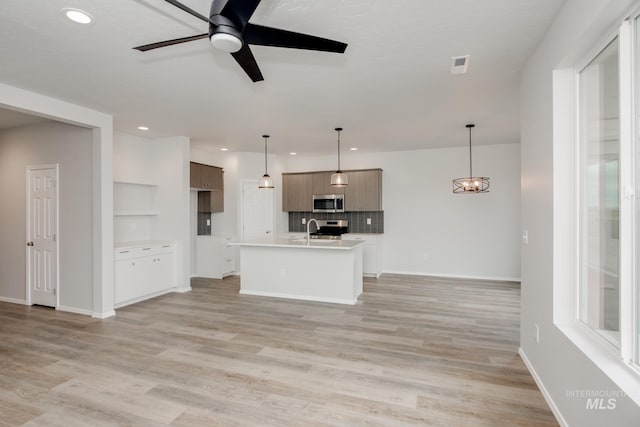 kitchen with visible vents, light wood-style flooring, open floor plan, stainless steel appliances, and light countertops