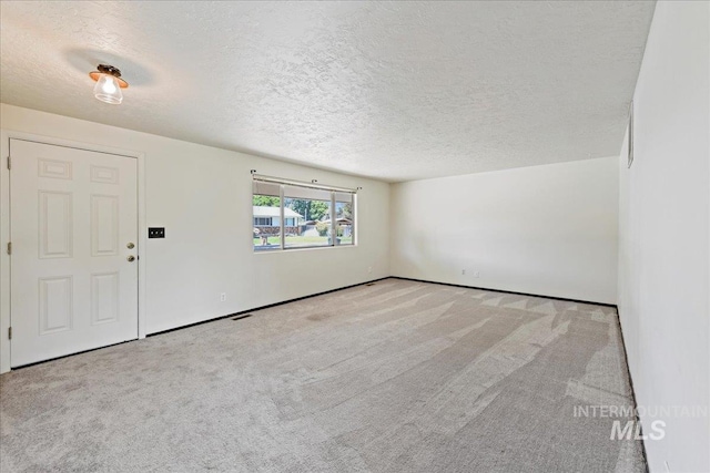 406 N Pine St, Emmett, ID 83617 - spare room with a textured ceiling, carpet flooring, and baseboards